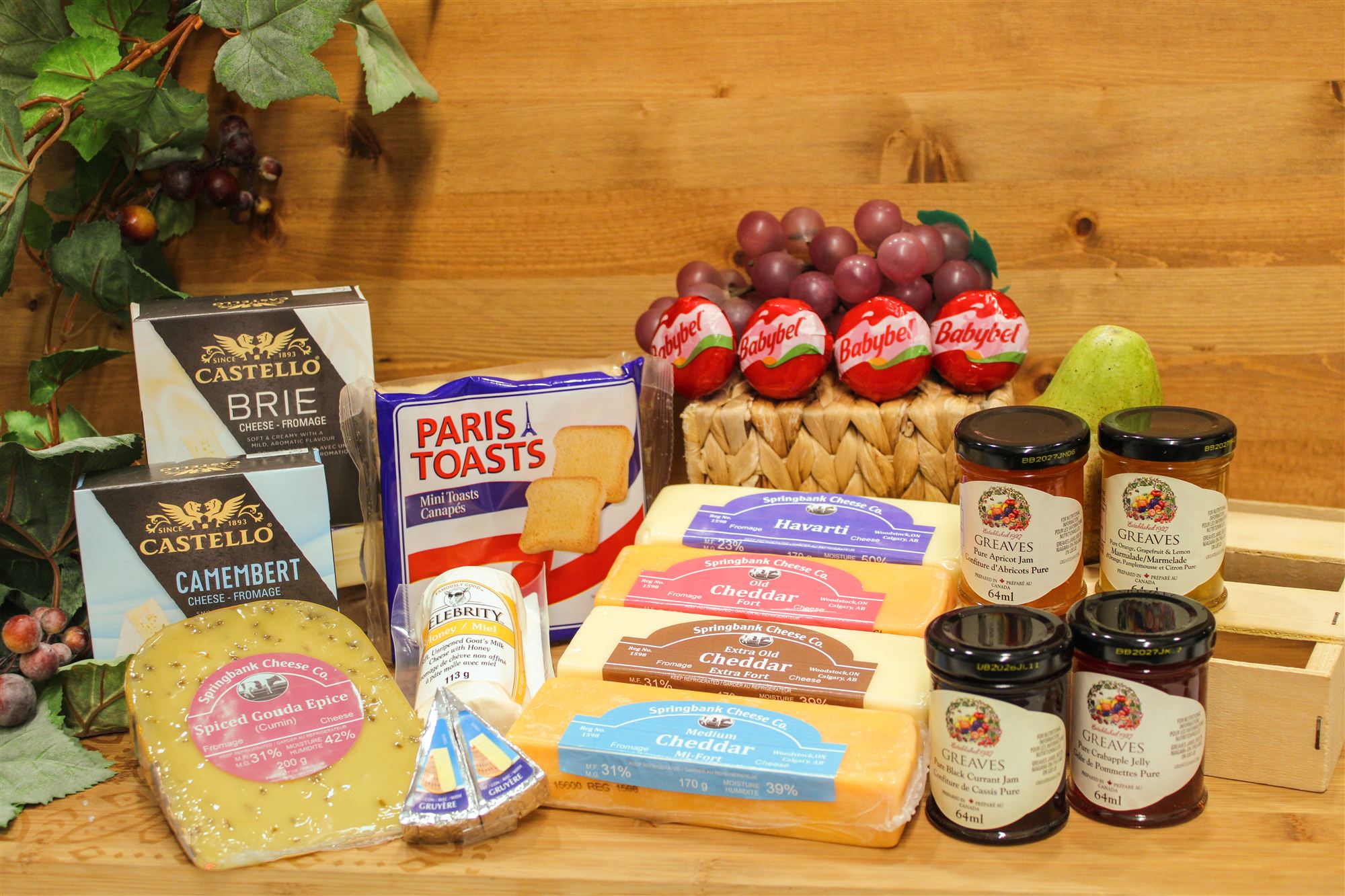 A full Springbank wholesale spread: cheeses, jams, and crackers on a wood counter